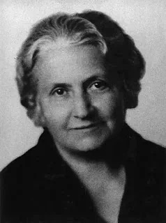 Portrait en noir et blanc de Maria Montessori âgée, regard posé et bienveillant