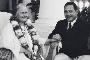 Portrait en noir et blanc de Maria Montessori et son fils Mario souriants, Maria ornée de guirlandes de fleurs traditionnelles indiennes, lors de leur séjour en Inde